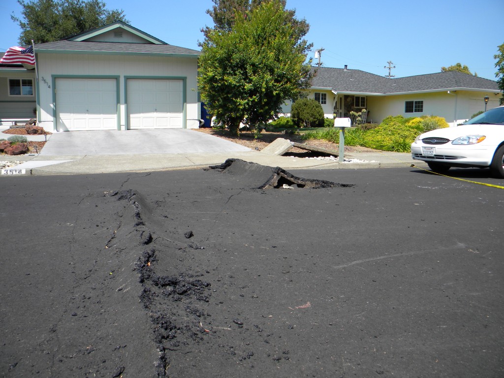 Fault damage in the suburbs west of Napa, California from the August 24th magnitude 6 earthquake. The fault rupture ran through homes and across roads, buckling the tarmac surface and pavements, resulting in damage expected to cost hundreds of millions of dollars. Photo credit: Austin Elliott, UC Davis.